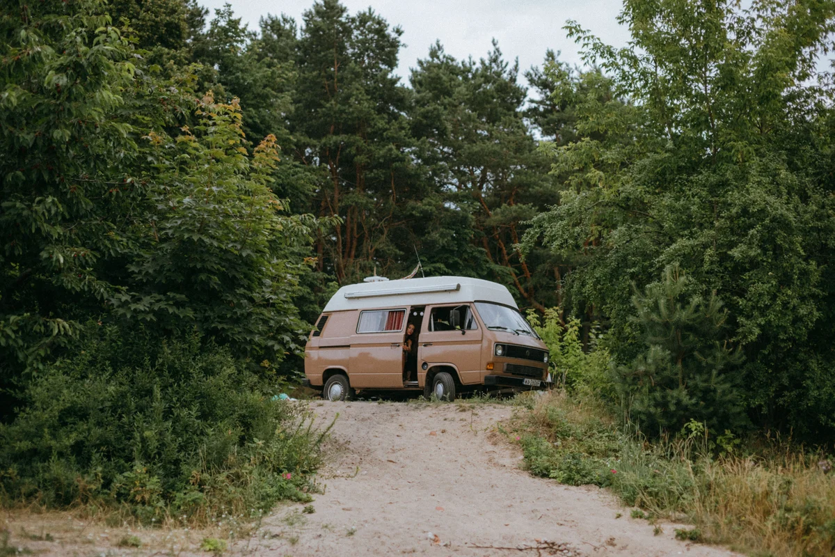 Retro Campervan auf grünen Waldweg geparkt, Vanlife in der Natur