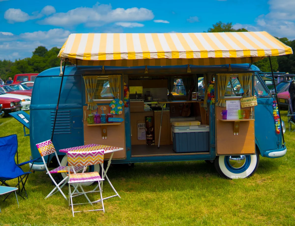 Bunter VW Camper mit geordnetem Festival-Campingplatz