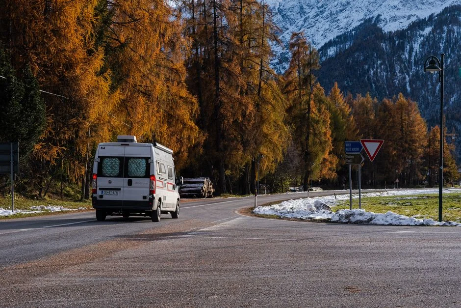 Campervan auf einer kurvigen Bergstraße im Herbst
