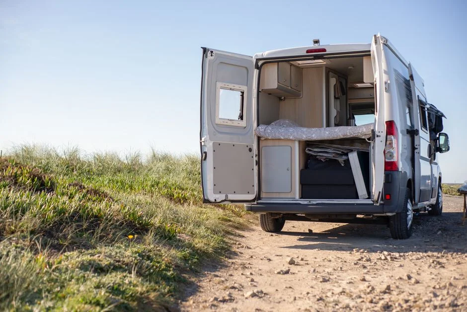 Familie beim Camping mit Campervan auf Campingplatz