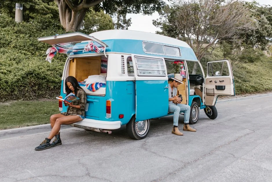 Paar an einem geöffneten Campervan bei einer hellen Reisevorbereitung