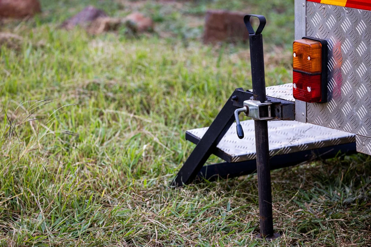 Anhängerkupplung und Stützrad an einem Anhänger im Gras