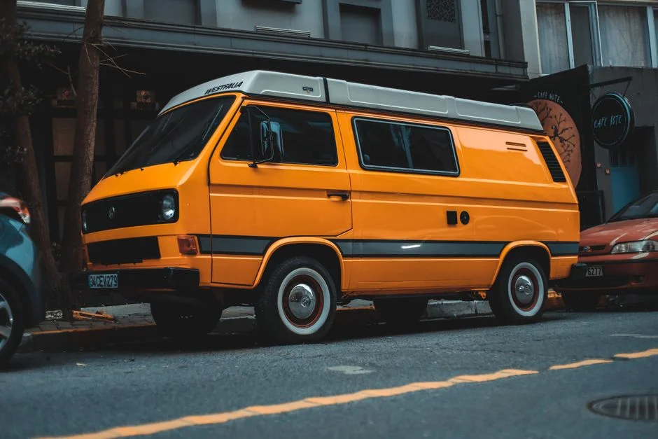 Oranger VW Bus mit Aufstelldach am Straßenrand