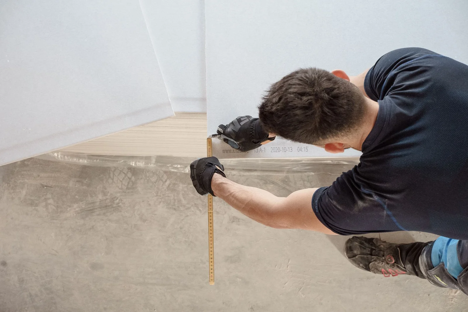 Handwerker misst und schneidet Bodenplatten aus Holz