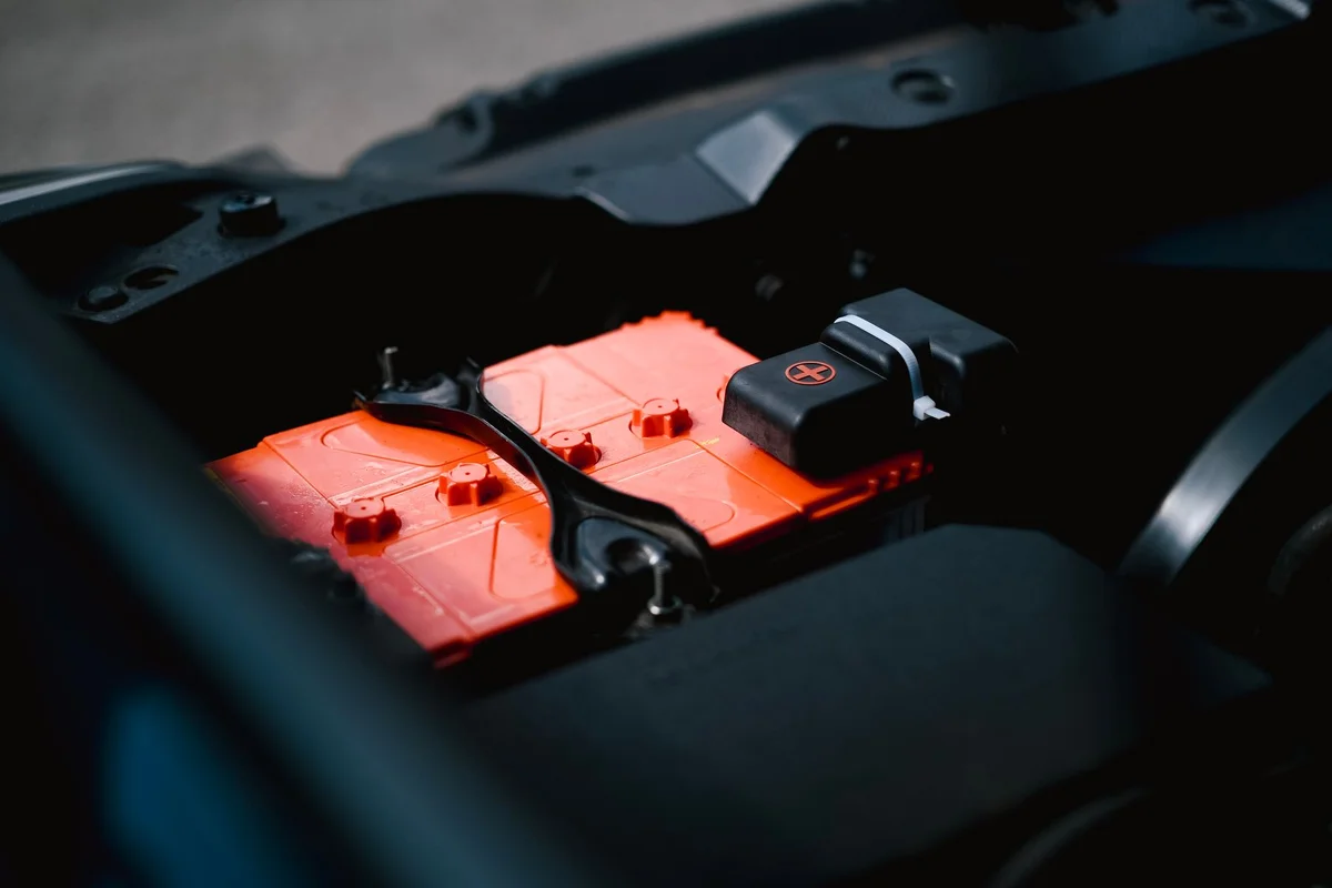 Batterie liegt sichtbar im Motorraum eines Fahrzeugs