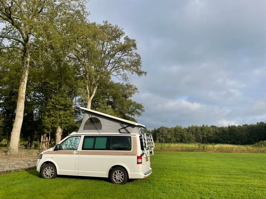Campingvan am Stellplatz mit offener Heckklappe und sichtbarem Laderaum