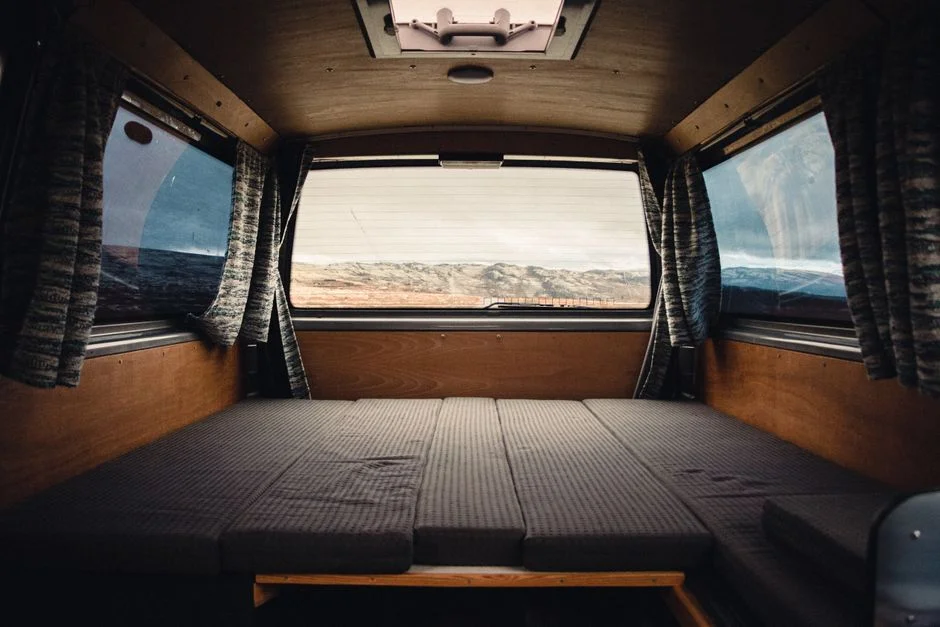 Innenausbau eines Camper-Vans mit Schlafbereich aus hellem Holz