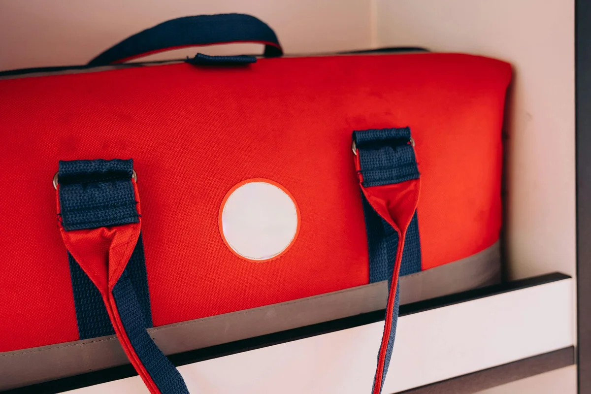 Rote Reisetasche liegt geordnet auf einem Stauraumfach